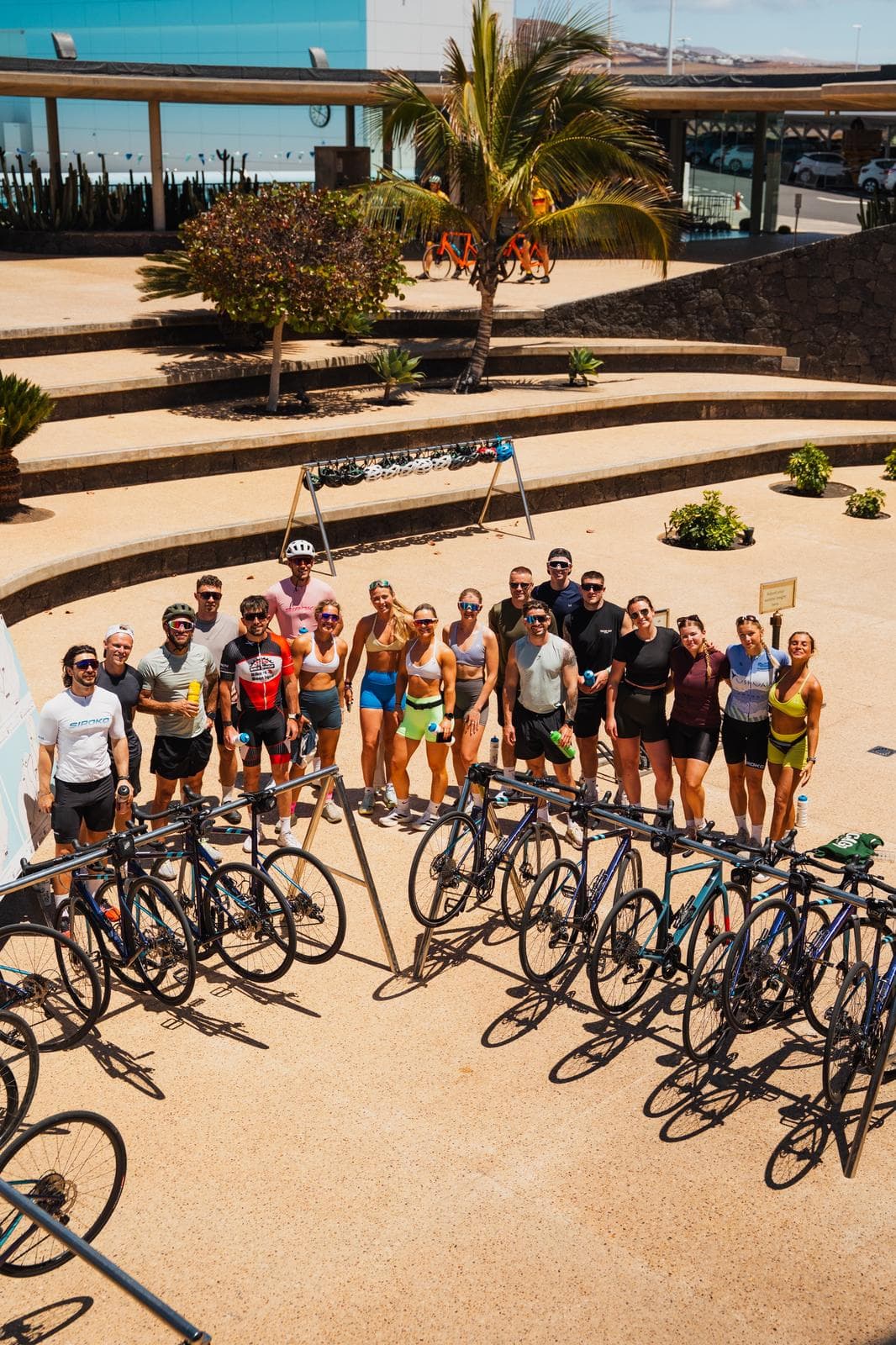 The full cycling group posing with bikes after a ride