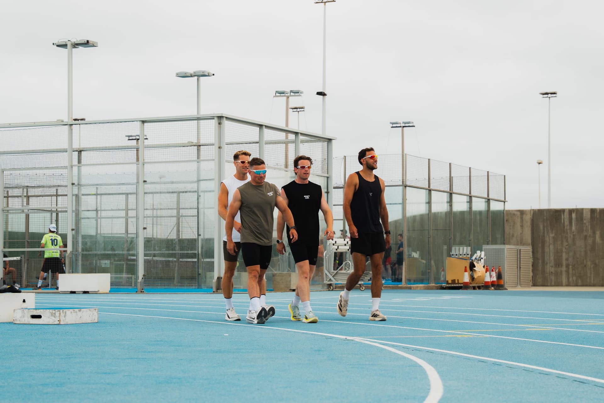 Two athletes carrying sandbags during an outdoor training session